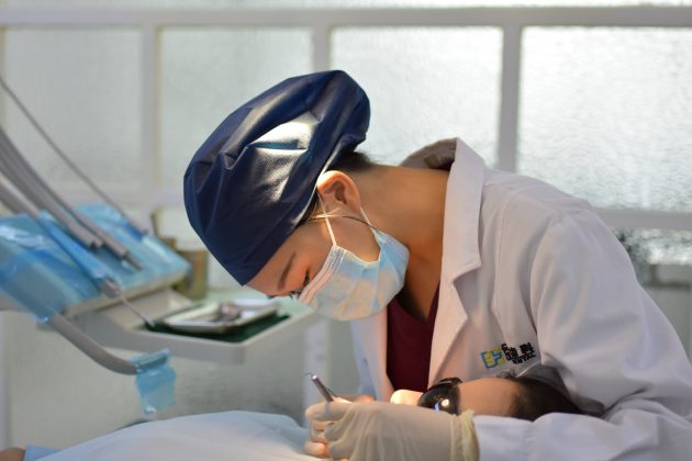 When Doctors Double as Medical Interpreters woman in white button up shirt wearing blue face mask