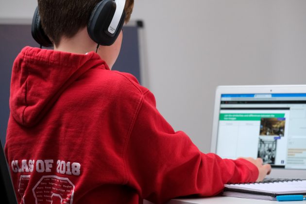 Improving Remote Learning Outcomes for Multilingual Students boy in red hoodie wearing black headphones