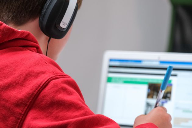Berlitz Develops AI-powered Language Learning Program person in red shirt wearing black and gray headphones